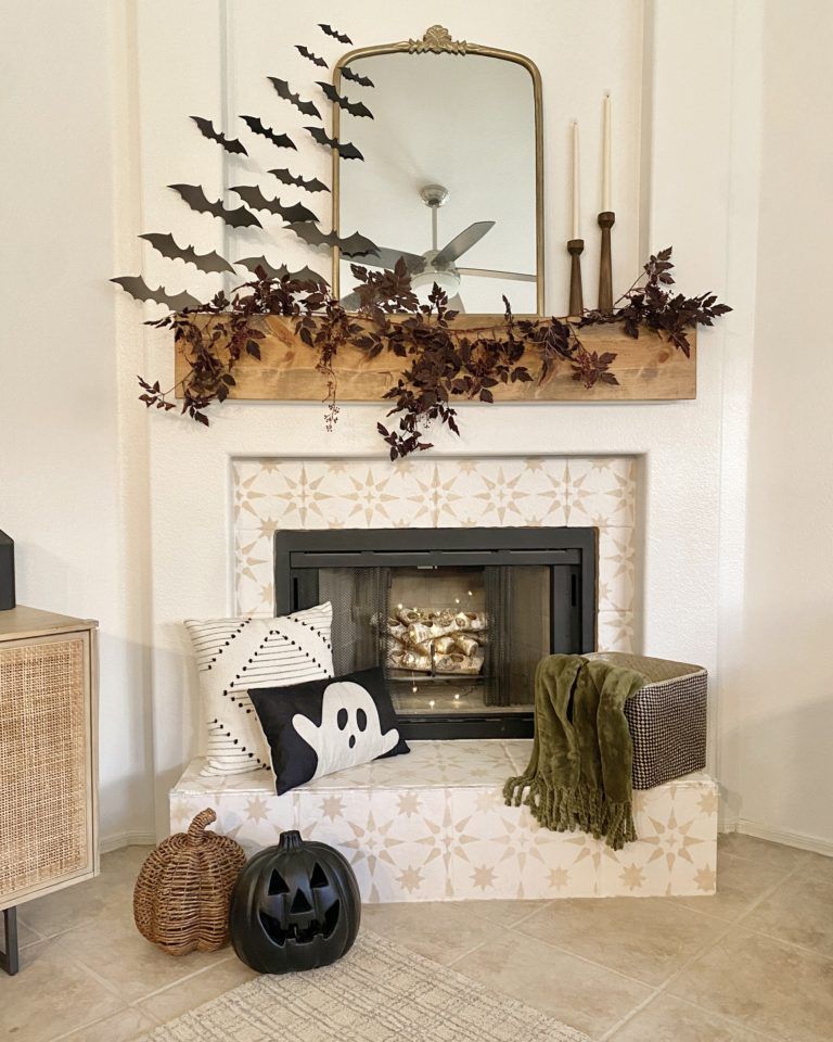 neutral halloween decorations. neutral halloween decor. halloween paper bats on wall. halloween fireplace decor. halloween decorations. ghost pillow. pumpkin pillow. fall garland. fireplace mirror.