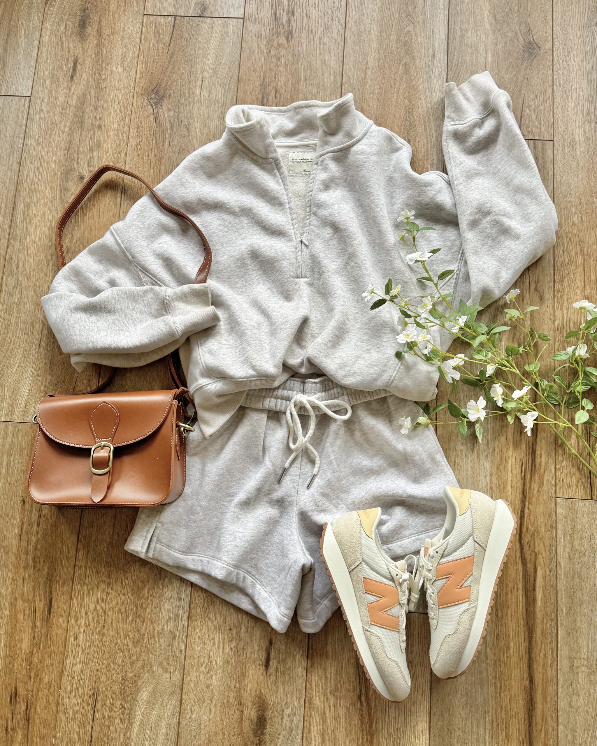 cozy sweat shorts set with  casual shorts and a matching quarter zip pullover sweatshirt. Perfect casual outfit for transitioning into spring. Everyday Spring Trends